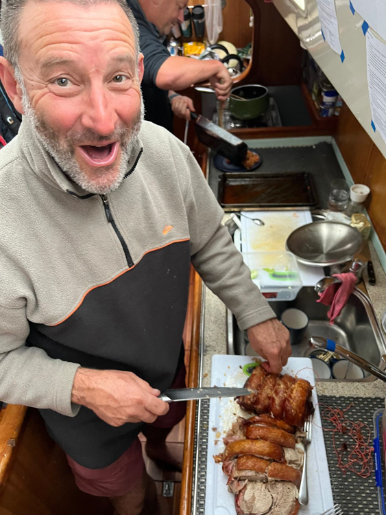 Rob carves roast pork in Schooner Cove