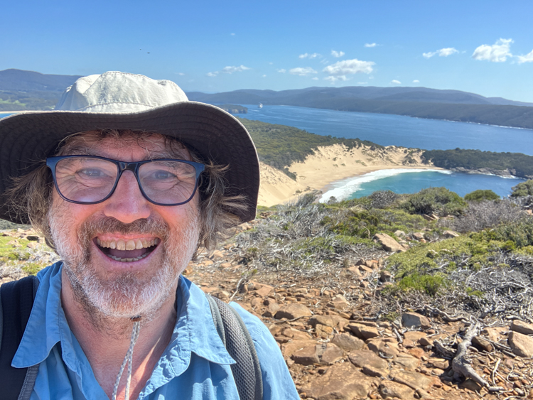 Reinhard at the summit of Mount Brown, with Crescent Beach behind